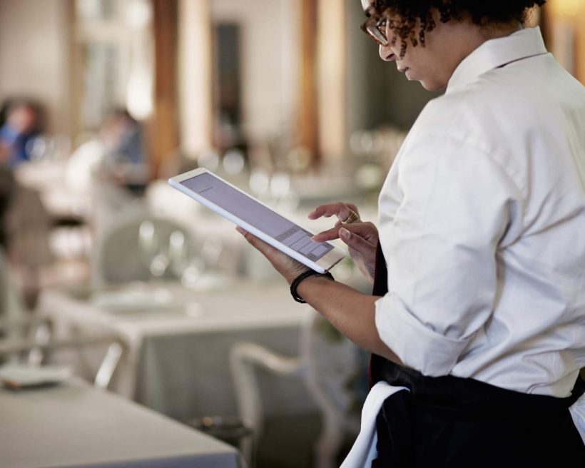 Restaurant owner holding a tablet to manage restaurant operations