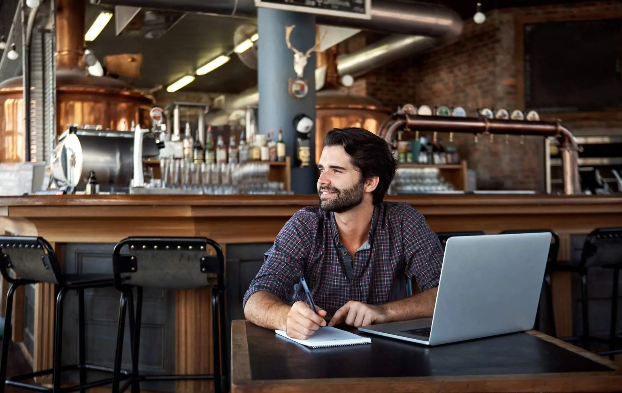 Image depicts a restaurant worker using a notepad and a computer.