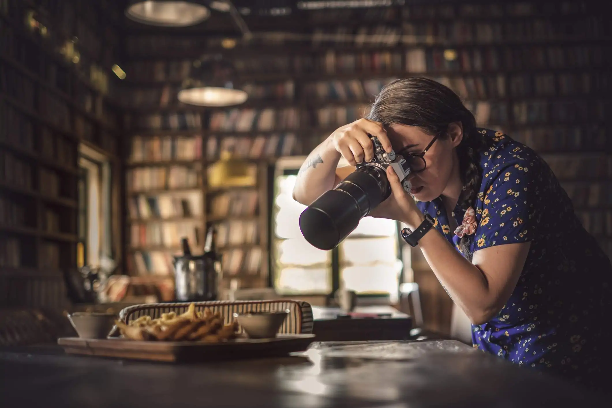 A food photographer is taking a picture of a dish in a restaurant